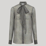 A gray and black herringbone patterned long-sleeve blouse with a large bow tie at the collar, from Gabriela Hearst, shown on a neutral light gray background.