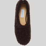 A top view of a fuzzy brown cashmere slipper shown on a plain grey background