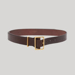 A dark brown leather belt with a gold-tone buckle, from Gabriela Hearst, displayed on a neutral light gray background.