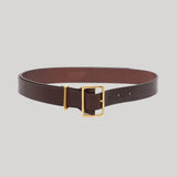A dark brown leather belt with a gold-tone buckle, from Gabriela Hearst, displayed on a neutral light gray background.