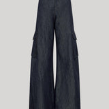 Dark blue wide-leg cargo pants made of denim-like fabric, featuring large flap side pockets, from Gabriela Hearst, shown against a solid light gray background.