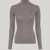 A ribbed knit turtleneck sweater in a muted taupe-gray color, from Gabriela Hearst, displayed on a ghost mannequin against a solid light gray background. 