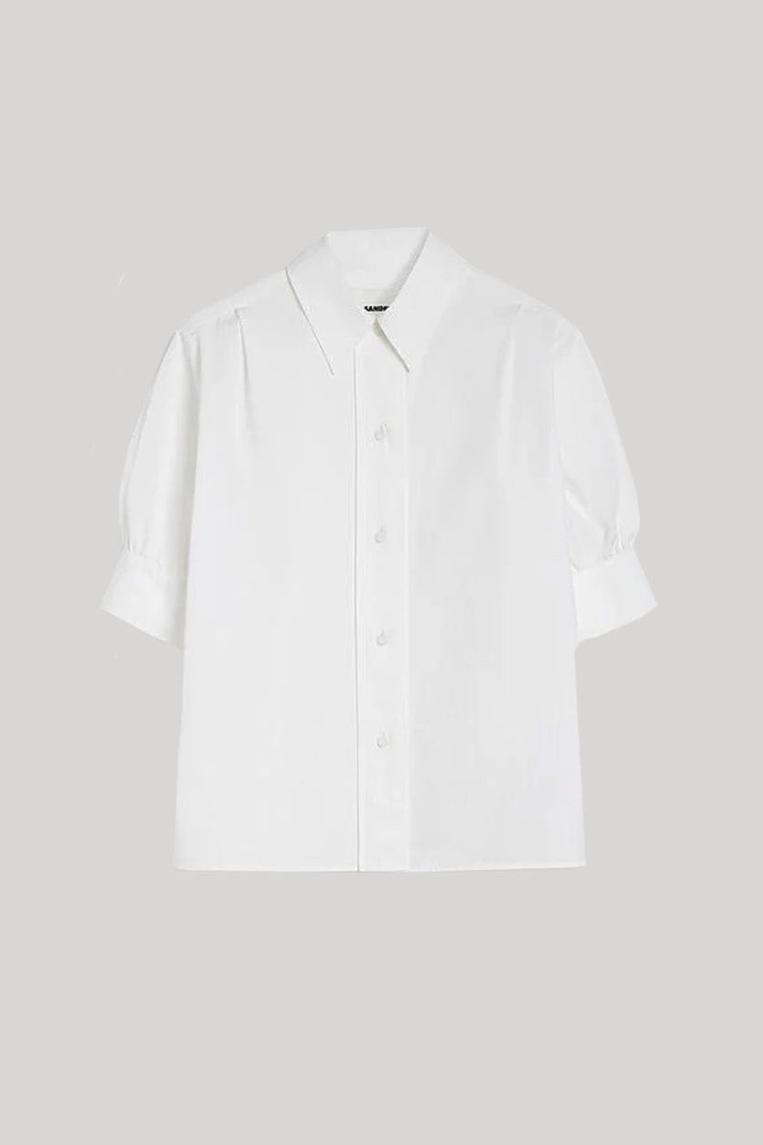 A white, short-sleeved, button-up shirt by Jil Sander, presented against a neutral background.