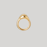 A gold teardrop-shaped ring with a smooth, polished finish, centered on a solid light gray background.
