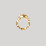 A gold teardrop-shaped ring with a smooth, polished finish, centered on a solid light gray background.