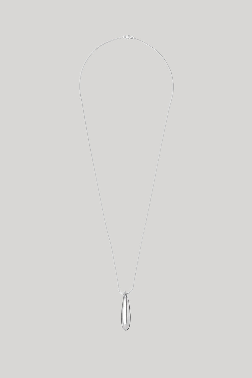 A minimalist silver teardrop pendant necklace on a fine silver chain, displayed against a solid light gray background.