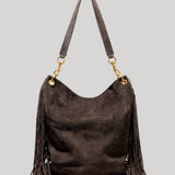 A dark brown suede hobo shoulder bag with long fringe detailing on the sides and a matching shoulder strap, accented by gold-tone hardware, from Nili Lotan, shown against a solid light gray background.