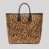 A leopard print tote bag with black handles and black trim, from Nili Lotan, shown against a solid light gray background.
