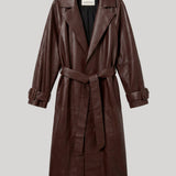 A dark brown leather trench coat with a matching waist tie belt, shown on a neutral light gray background. The jacket is from Nour Hammour