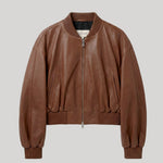 A brown leather bomber jacket with a ribbed collar, cuffs, and hem, featuring a front zipper and side pockets, shown against a solid light gray background. The jacket is from Nour Hammour