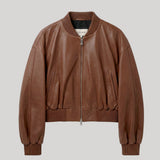 A brown leather bomber jacket with a ribbed collar, cuffs, and hem, featuring a front zipper and side pockets, shown against a solid light gray background. The jacket is from Nour Hammour
