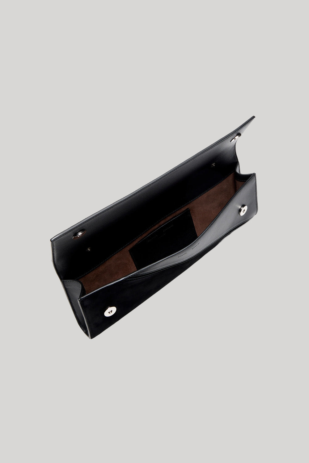 A black leather clutch bag with a brown suede-like interior lining, shown open against a solid light gray background.