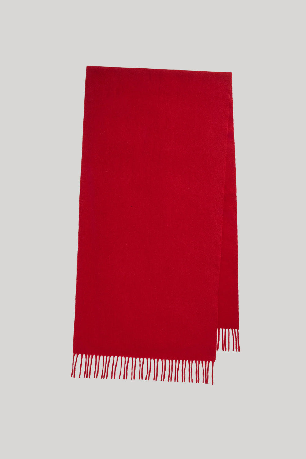 A bright red rectangular scarf with fringed edges, displayed flat against a solid light gray background.