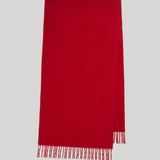 A bright red rectangular scarf with fringed edges, displayed flat against a solid light gray background.