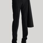 Black wide-leg trousers with a draped coat and white pointed-toe heels, shown on a model from the waist down against a light gray background.