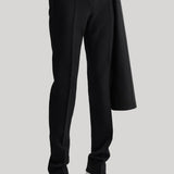 Black wide-leg trousers with a draped coat and white pointed-toe heels, shown on a model from the waist down against a light gray background.