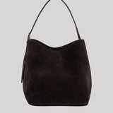 A dark brown suede hobo shoulder bag from Toteme with a single shoulder strap, shown against a solid light gray background.
