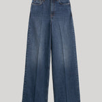 A pair of high-waisted, wide-leg blue denim jeans from Toteme with a faded wash, shown flat against a solid light gray background. 