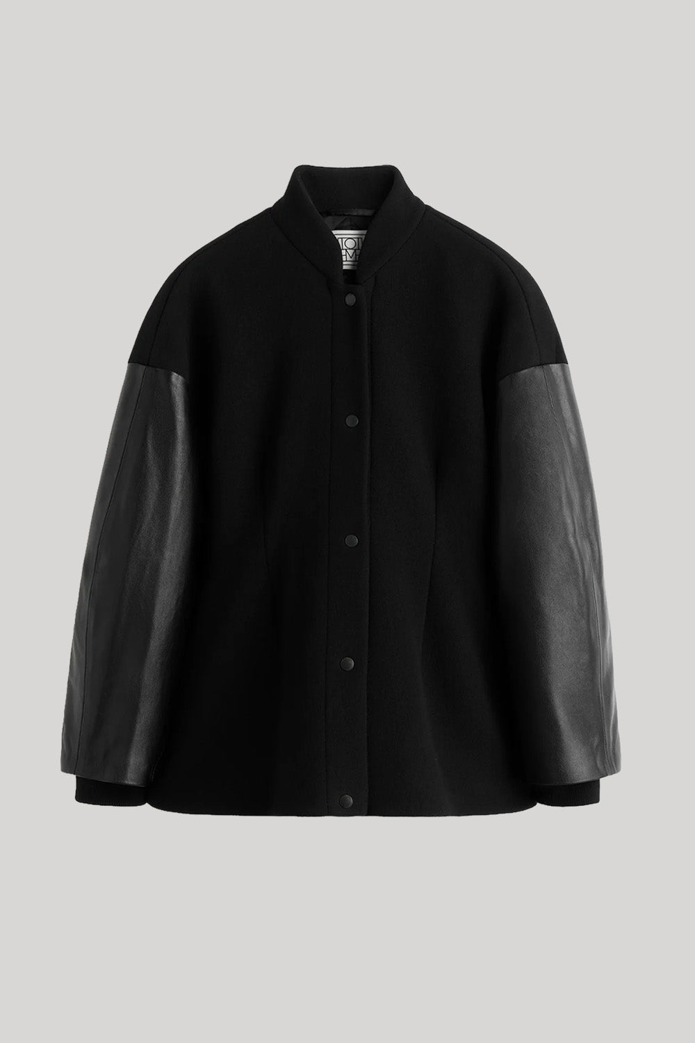 A black button-front jacket with contrasting black leather sleeves, shown against a solid light gray background. 